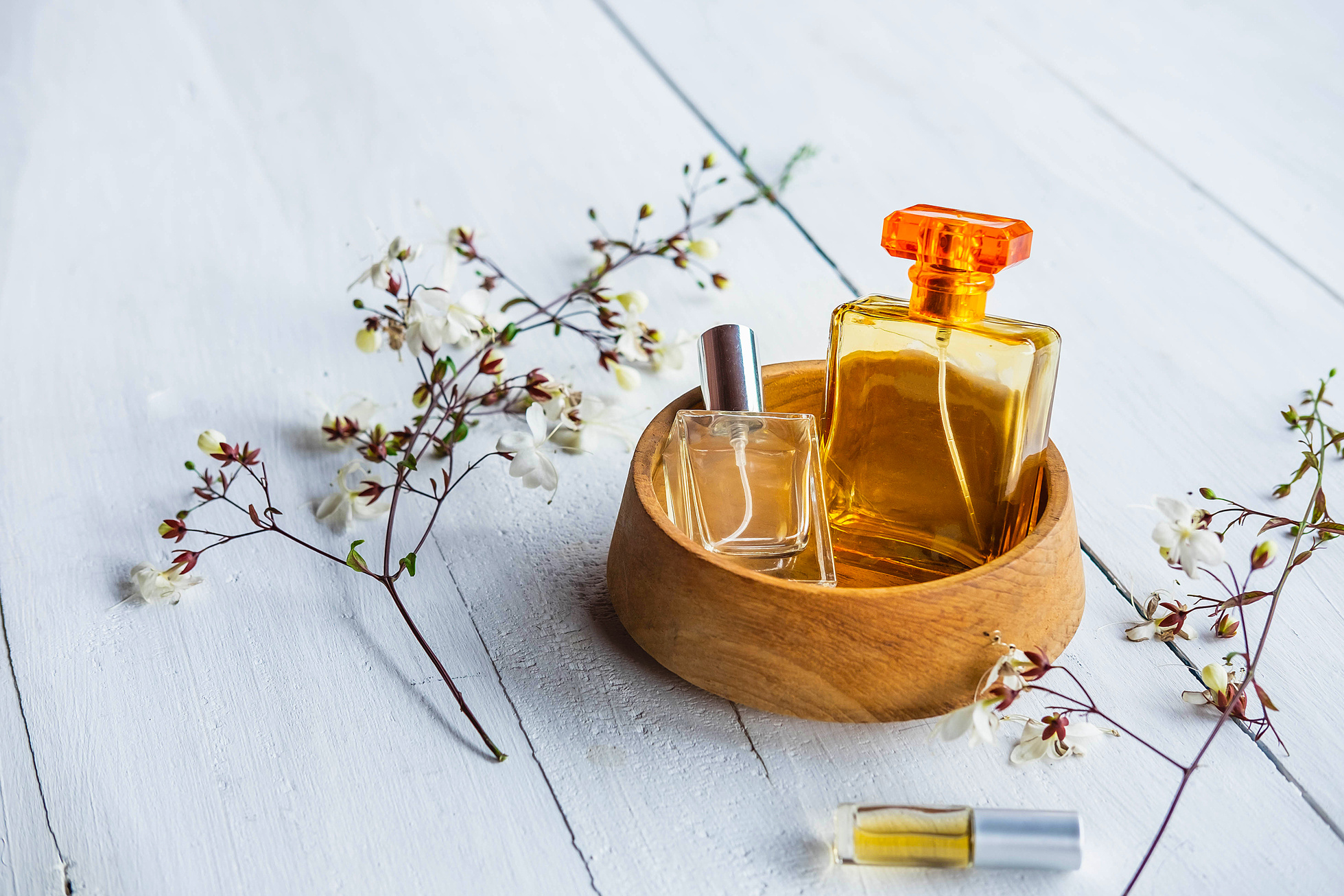 Perfume Bottle with Flowers on a Wooden Background